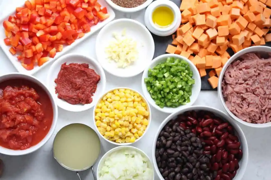 Chili ingredients in white bowls.