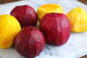 Peeled beets on marble cutting board.